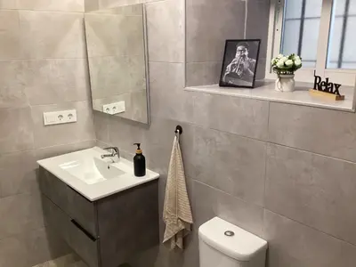 a bathroom with a sink and a toilet and a mirror at Apartamento La Guitarra in Jerez de la Frontera