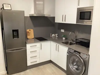 a kitchen with a refrigerator and a washing machine at Apartamento La Guitarra in Jerez de la Frontera