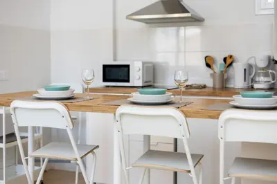 a kitchen with a table with plates and wine glasses at Brisa Jerez Suites in Jerez de la Frontera