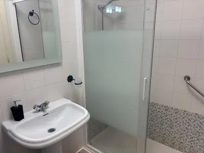 a bathroom with a glass shower and a sink at Acogedor apartamento, céntrico, recién restaurado in Jerez de la Frontera