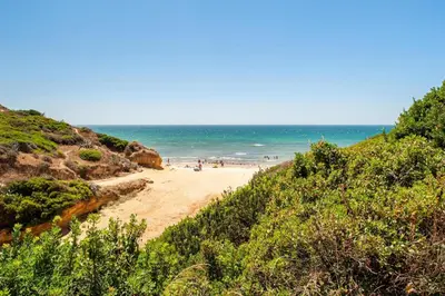 a beach with people on the sand and the ocean at Fuente del Sol in Conil de la Frontera