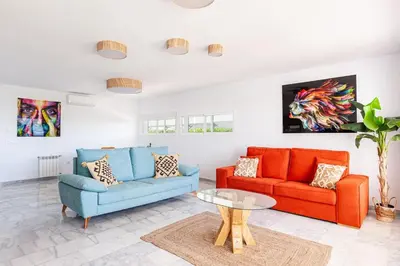a living room with two couches and a table at Fuente del Sol in Conil de la Frontera