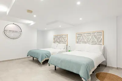 a bedroom with two beds and a mirror at Fuente del Sol in Conil de la Frontera
