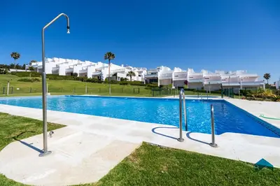 a swimming pool in front of a apartment building at Fuente del Sol in Conil de la Frontera