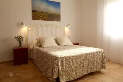 a bedroom with a white bed with two pillows at Hacienda Laguna Seca - Apart. Lavanda in Chiclana de la Frontera