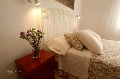 a bedroom with a bed and a vase of flowers on a table at Hacienda Laguna Seca - Apart. Lavanda in Chiclana de la Frontera
