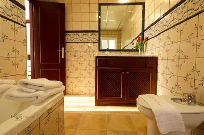 a bathroom with a sink and a toilet and a mirror at Hacienda Laguna Seca - Apart. Lavanda in Chiclana de la Frontera