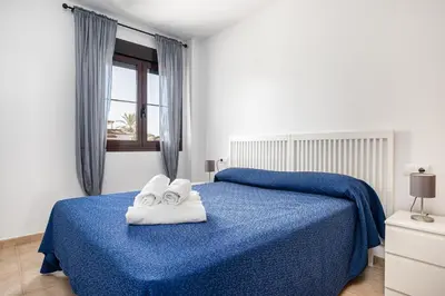 a bedroom with a blue bed with towels on it at coto 2 18 in Chiclana de la Frontera