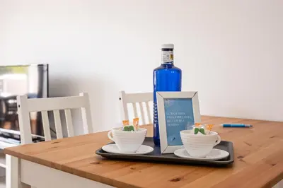 a bottle of wine and two cups on a wooden table at coto 2 18 in Chiclana de la Frontera