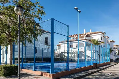a fence with blue poles in front of some buildings at coto 2 18 in Chiclana de la Frontera