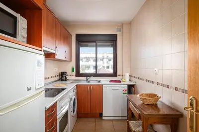 a kitchen with a white refrigerator and a sink at Coto 10 11 in Chiclana de la Frontera