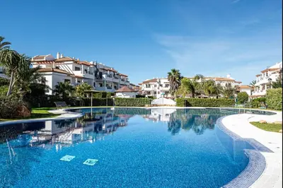 a swimming pool in a resort with houses in the background at Coto 10 11 in Chiclana de la Frontera