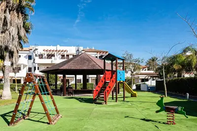 a playground with a slide and a play structure at Coto 10 11 in Chiclana de la Frontera