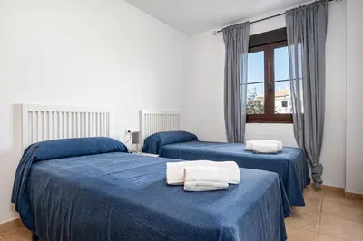 two beds in a room with blue sheets at Coto 10 11 in Chiclana de la Frontera
