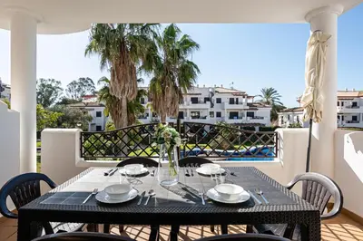 a dining table on a balcony with a view of the ocean at Coto 10 11 in Chiclana de la Frontera
