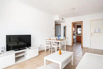 a living room with a television and a table at coto 9 16 in Chiclana de la Frontera