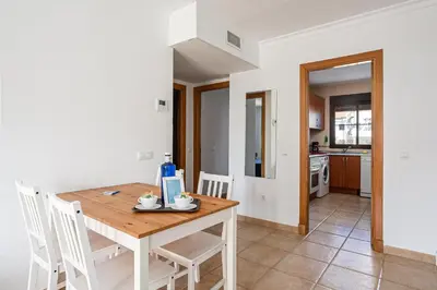a kitchen and dining room with a wooden table and chairs at coto 9 16 in Chiclana de la Frontera