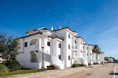 a white building with balconies on a street at coto 9 16 in Chiclana de la Frontera