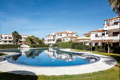 a swimming pool in front of some apartment buildings at coto 9 16 in Chiclana de la Frontera