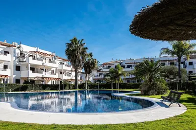 a swimming pool in front of a building at coto 4 17 in Chiclana de la Frontera