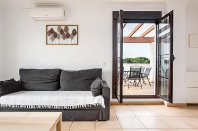 a living room with a couch and a patio at coto 8 22 in Chiclana de la Frontera