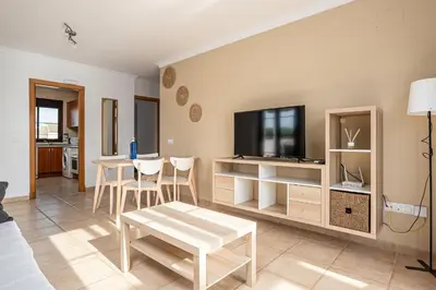 a living room with a table and a tv at coto 8 22 in Chiclana de la Frontera