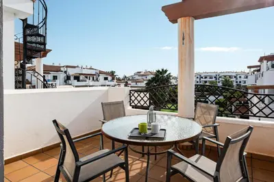 a table and chairs on a balcony with a view at coto 8 22 in Chiclana de la Frontera