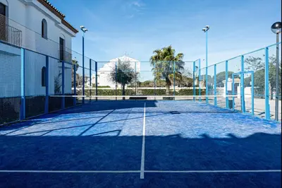 a tennis court in front of a building at coto 8 22 in Chiclana de la Frontera