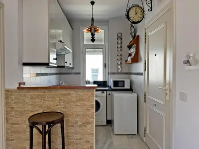 a kitchen with a counter and a clock on the wall at Larga Suite 46 - Ole Solutions in Jerez de la Frontera
