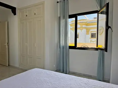 a bedroom with a bed and a window and a door at Larga Suite 46 - Ole Solutions in Jerez de la Frontera