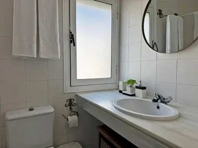 a bathroom with a sink and a mirror and a toilet at Larga Suite 46 - Ole Solutions in Jerez de la Frontera