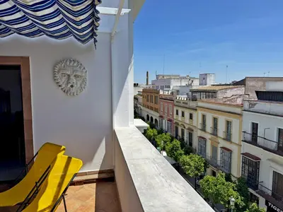 a balcony with a clock on the side of a building at Larga Suite 46 - Ole Solutions in Jerez de la Frontera