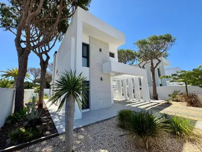 a white house with trees in front of it at Villa Agua Salá in Poblado de Sancti Petri
