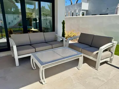 a couch and a coffee table on a patio at Villa Agua Salá in Poblado de Sancti Petri