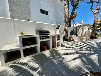 a barbecue grill in a backyard with a fence at Villa Agua Salá in Poblado de Sancti Petri