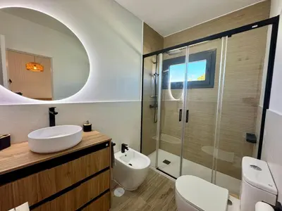 a bathroom with a sink and a glass shower at Villa Agua Salá in Poblado de Sancti Petri