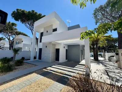 a white house with trees in front of it at Villa Agua Salá in Poblado de Sancti Petri