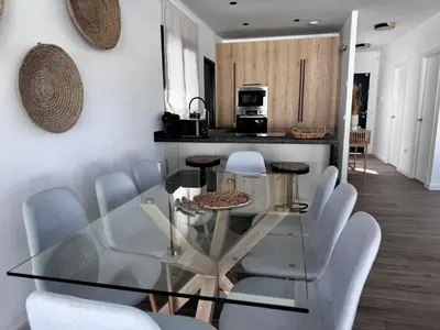 a dining room with a glass table and chairs at Villa Agua Salá in Poblado de Sancti Petri
