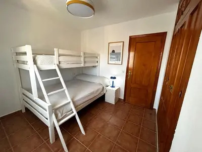 a bedroom with a bunk bed with a ladder at Relax rooftop in the palm trees in Novo Sancti Petri