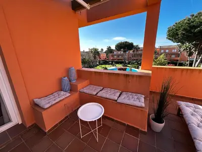 a balcony with a bench and a table at Relax rooftop in the palm trees in Novo Sancti Petri