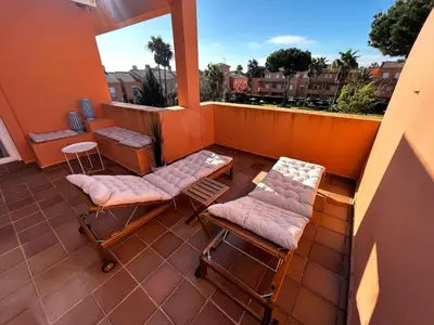 a balcony with two chairs and two stools at Relax rooftop in the palm trees in Novo Sancti Petri