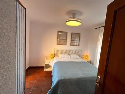 a bedroom with a bed with a blue blanket at Relax rooftop in the palm trees in Novo Sancti Petri