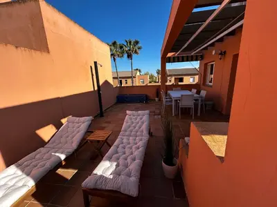 a patio with chairs and a table on a building at Relax rooftop in the palm trees in Novo Sancti Petri