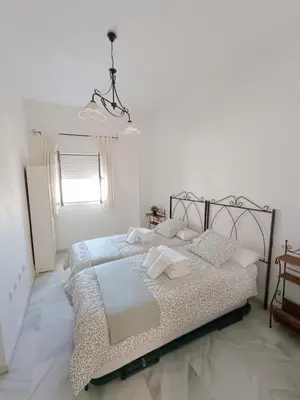 a bedroom with a bed with white sheets and a window at Ribera del río - Centro in El Puerto de Santa María
