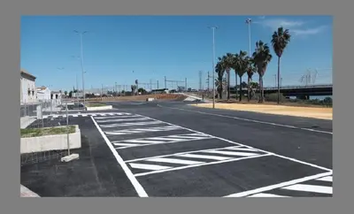 an empty parking lot with palm trees and a bridge at Ribera del río - Centro in El Puerto de Santa María