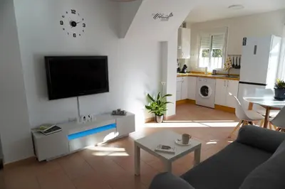 a living room with a couch and a tv on a wall at Brisa Marina in Sanlúcar de Barrameda