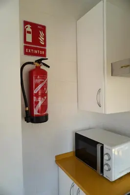 a kitchen with a microwave and a fire extinguisher on the wall at Brisa Marina in Sanlúcar de Barrameda