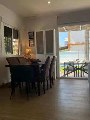 a dining room with a table and chairs with a view of the ocean at Sunset Palm in El Puerto de Santa María