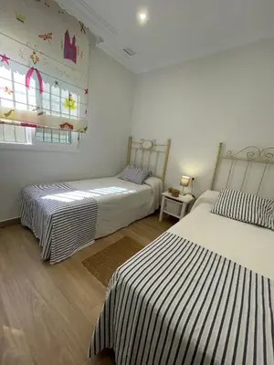 a room with two beds and a window at Sunset Palm in El Puerto de Santa María