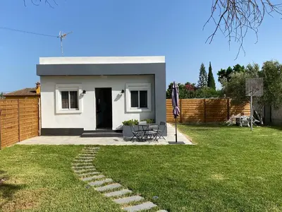 a small white house with a table in a yard at Villa Hebane in El Puerto de Santa María